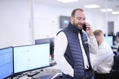 Account Manager speaking with a customer while working in a modern sales office