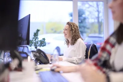 Pricing analyst working with colleagues in a modern office environment