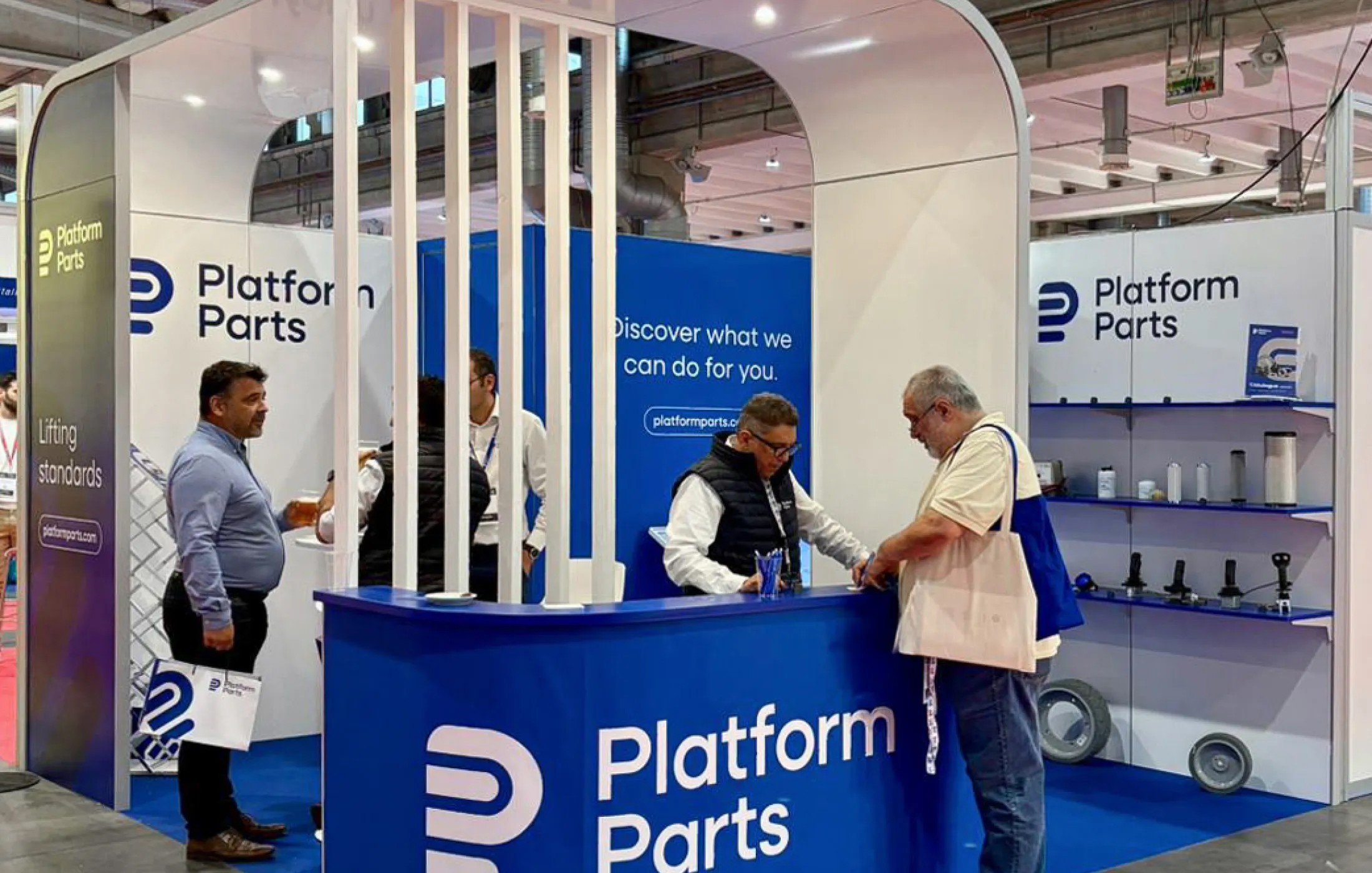 Platform Parts exhibition booth at GIS, with staff members assisting visitors and product displays showcasing aerial work platform components.